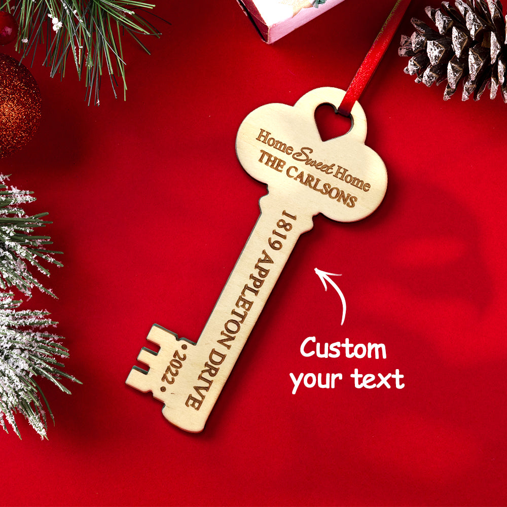 Personalized wooden key Christmas ornament, ideal housewarming gift, featuring custom text on a red ribbon.