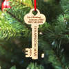 Personalized wooden key Christmas ornament for new home, with custom text on a red ribbon, perfect housewarming gift.