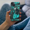 iPhone 13 case featuring a turquoise and black cat design, TPU material, wireless charging compatible.