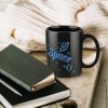 Black ceramic Space mug on wooden surface with notebooks and a pen, perfect gift.