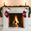Christmas stockings hanging on a fireplace, with red body, white cuff, and festive design.