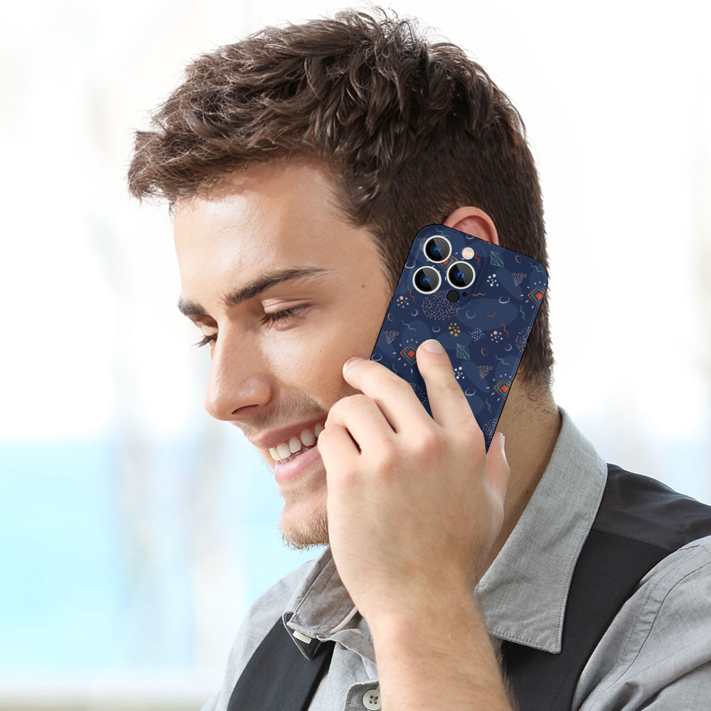 Man talking on iPhone 13 with a dark blue celestial pattern PC plastic case, protecting phone.