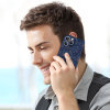 Man talking on iPhone 13 with a dark blue celestial pattern PC plastic case, protecting phone.