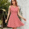 Coral sleeveless polka dot dress with V-neck and high waist, perfect for everyday wear.