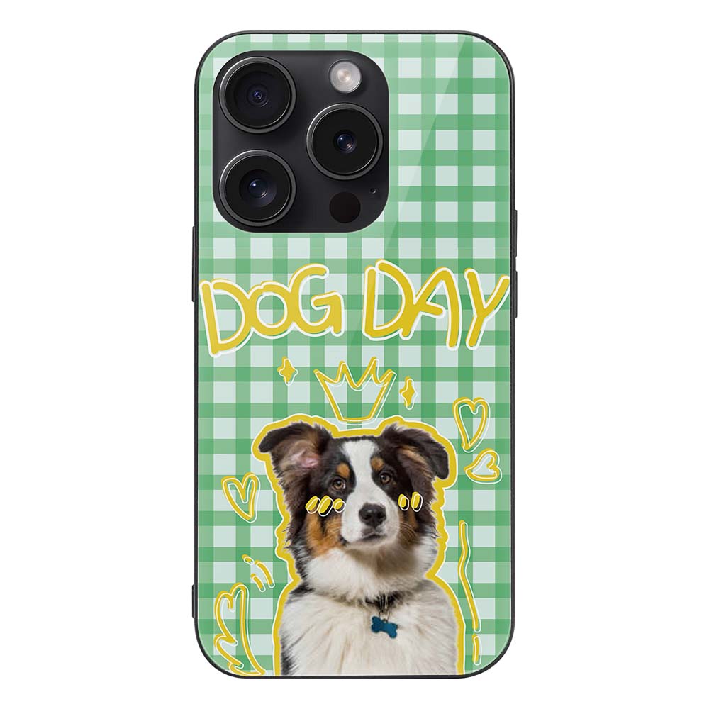 iPhone 15 case with dog graphic and "DOG DAY" text on a green gingham pattern, glass + TPU material.