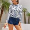 White long sleeve shirt with blue paisley pattern for women. Polyester-spandex blend, perfect for casual wear.