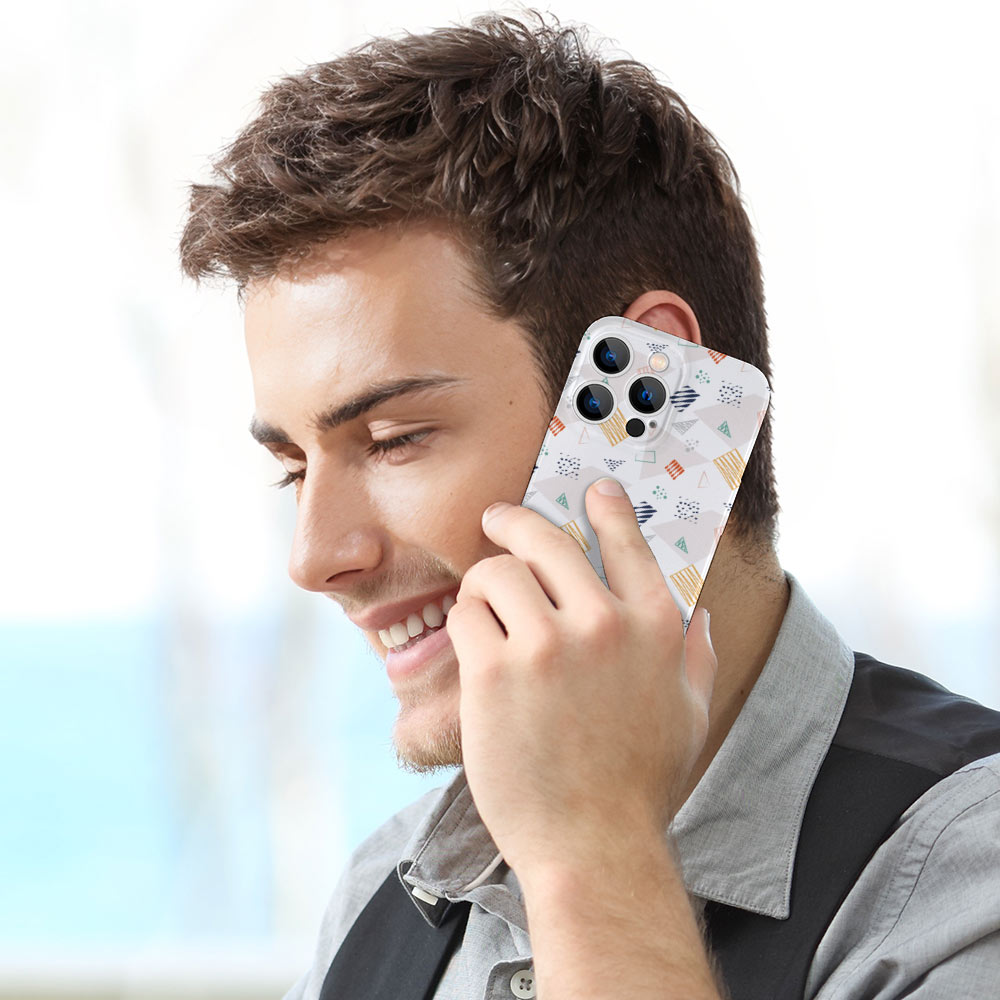Man using iPhone 13 with white patterned PC plastic case, protecting the phone while talking.
