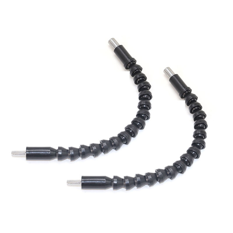 Flexible shaft lying across a workbench near a set of loose drill bits