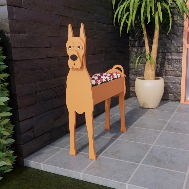 Tan Great Dane planter with red and white flowers filling the back trough