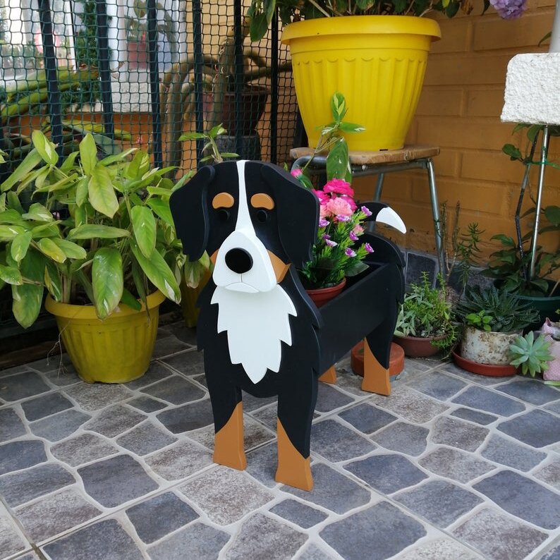 Bernese mountain dog planter with pink flowers on an outdoor patio