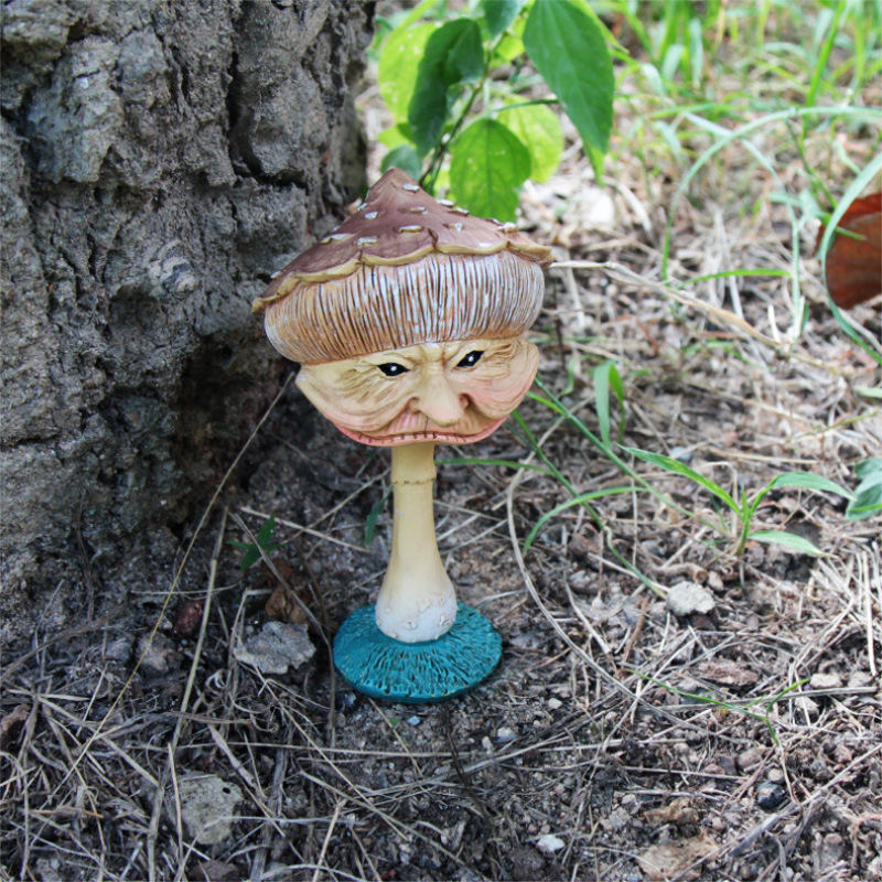 Mushroom figure at the base of a tree in garden soil