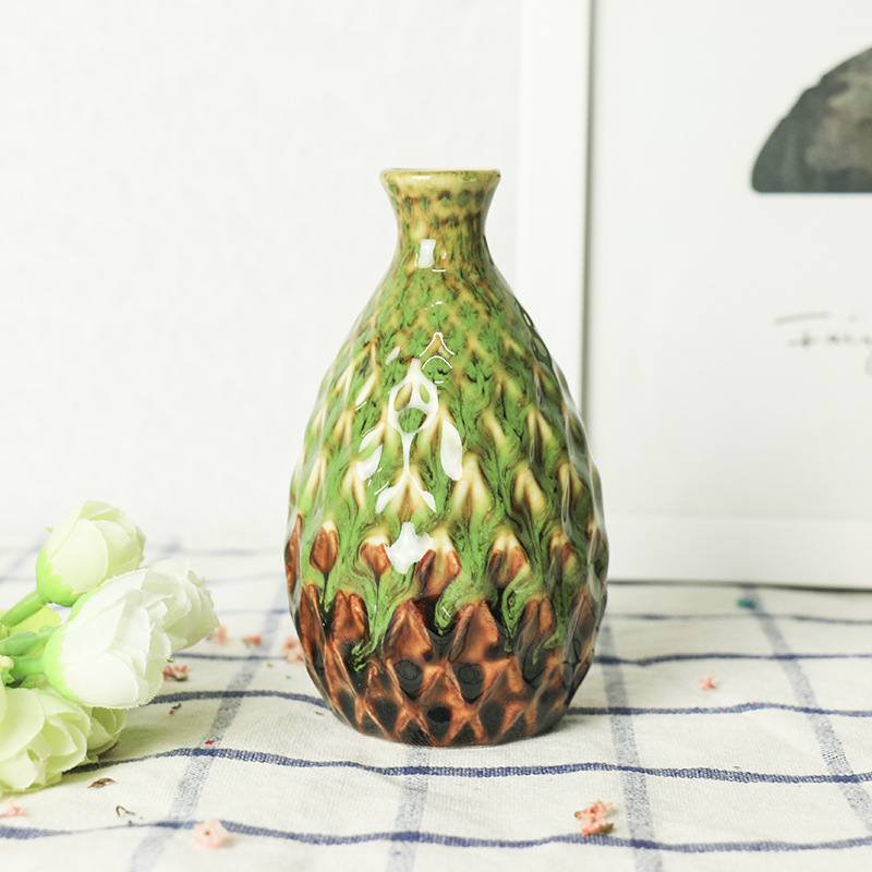 Single green ceramic vase with brown textured base and relief scales
