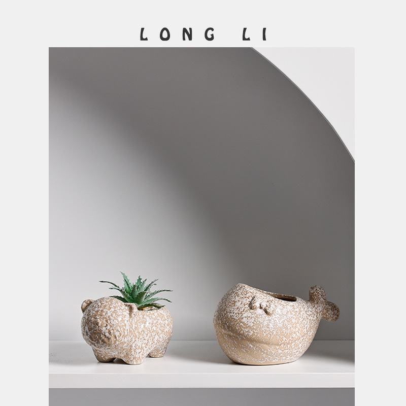 Two animal-shaped planters with a succulent on a white shelf