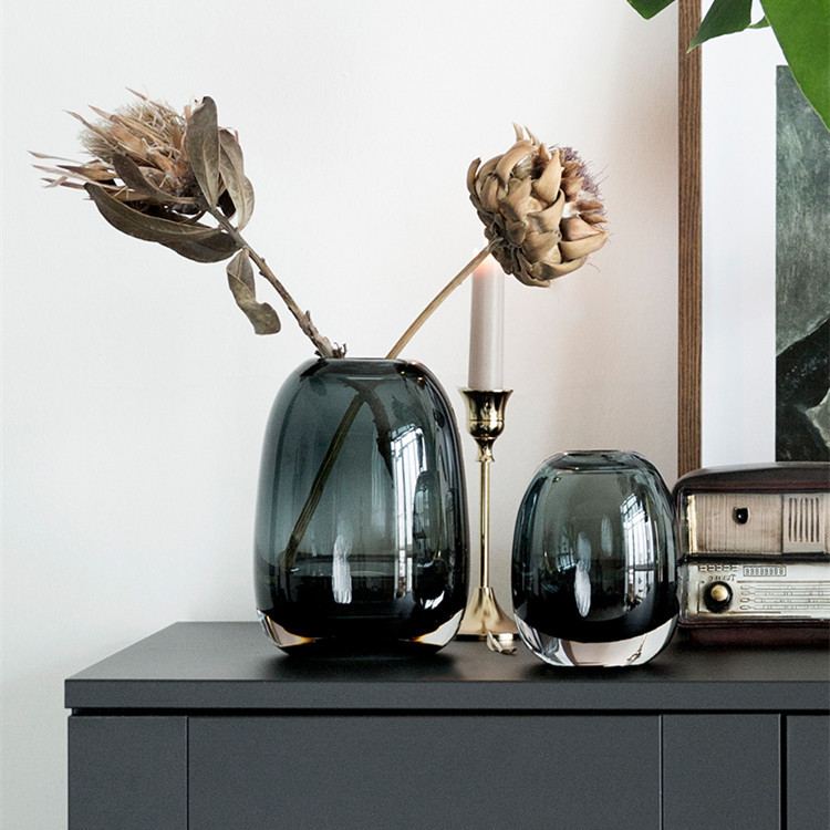 Smoky blue glass vase anchoring a styled living room sideboard
