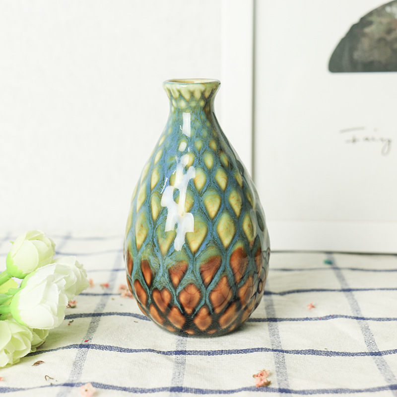 Glazed mini ceramic vase with textured body set on a tabletop