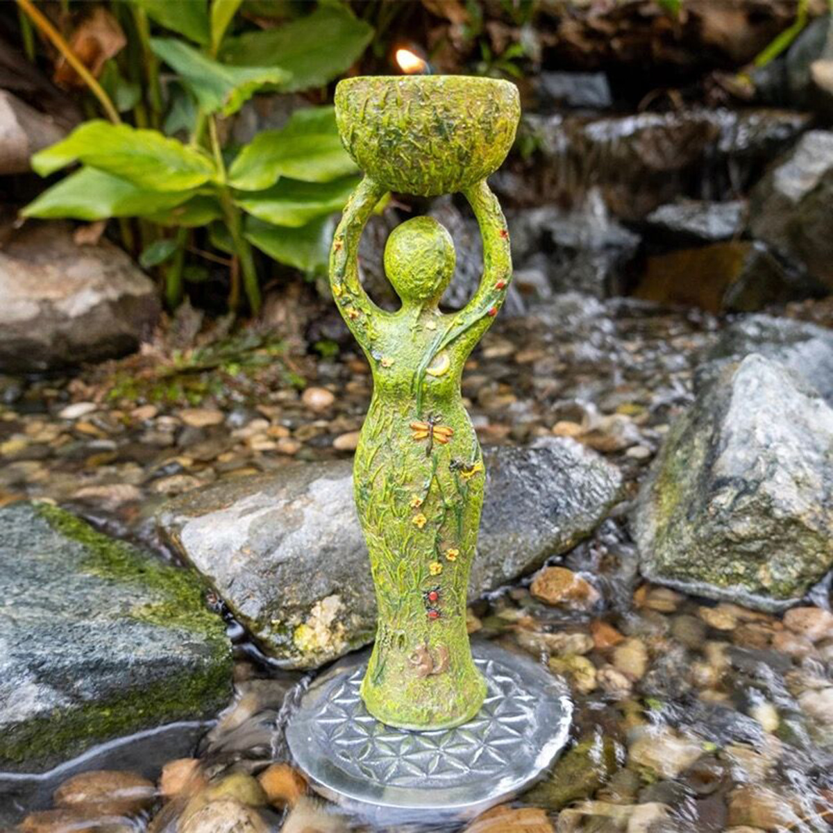 Goddess tea light holder with a lit candle in the crown bowl
