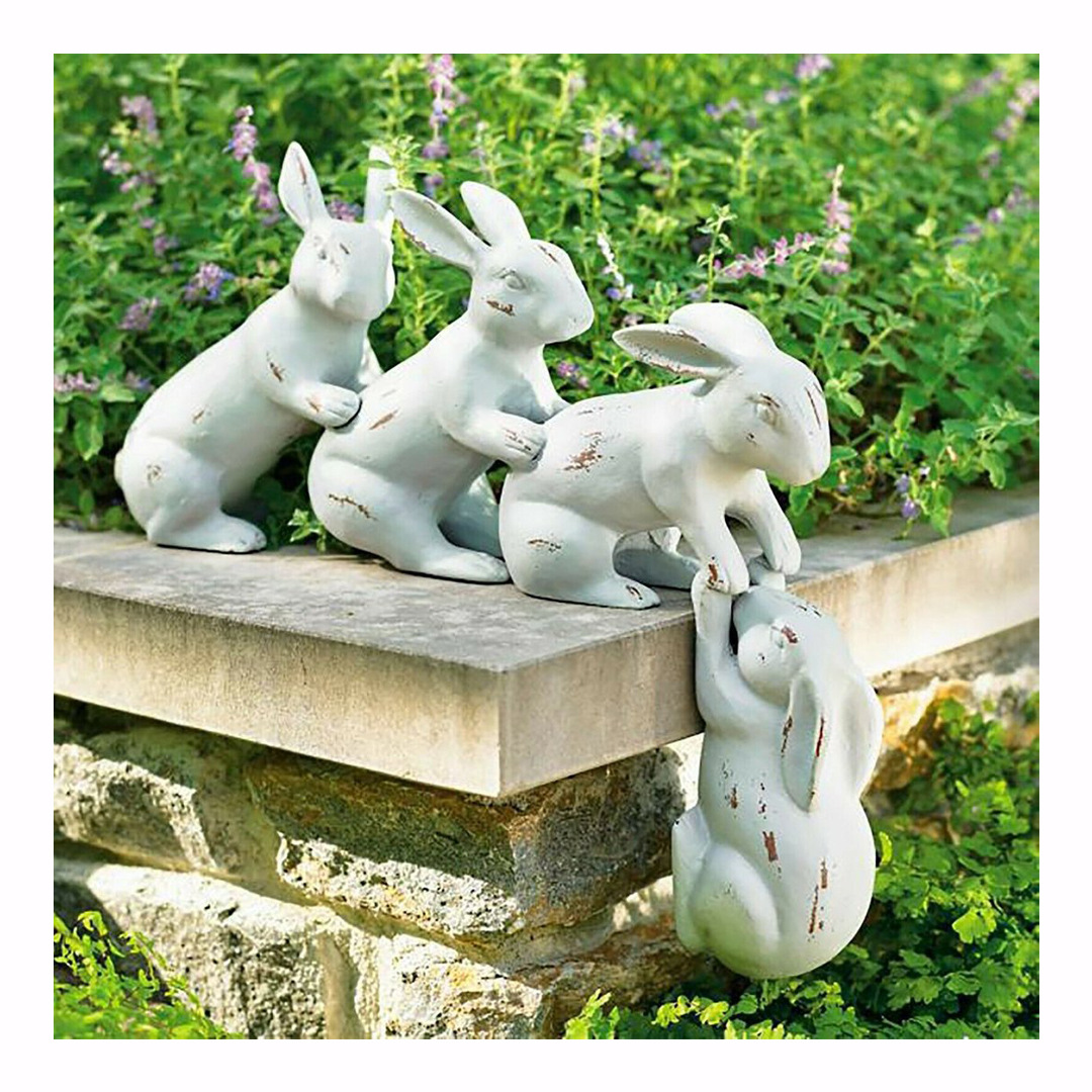 Square crop of four rabbits on a garden wall with lush greenery