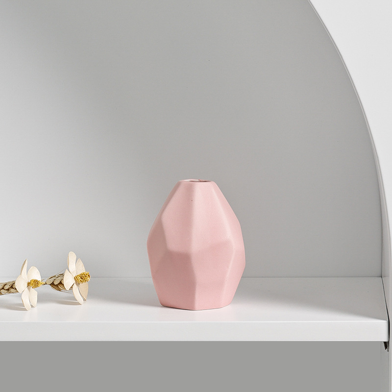 Pastel faceted vases in mint and blush arranged on a styled shelf