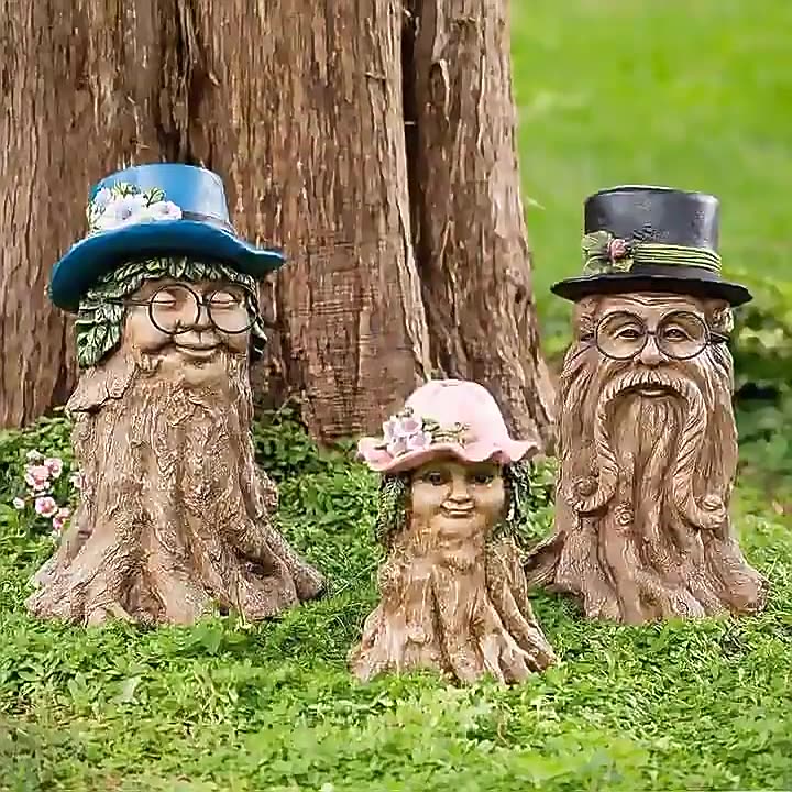Three tree stump figures standing in grass at the base of a tree