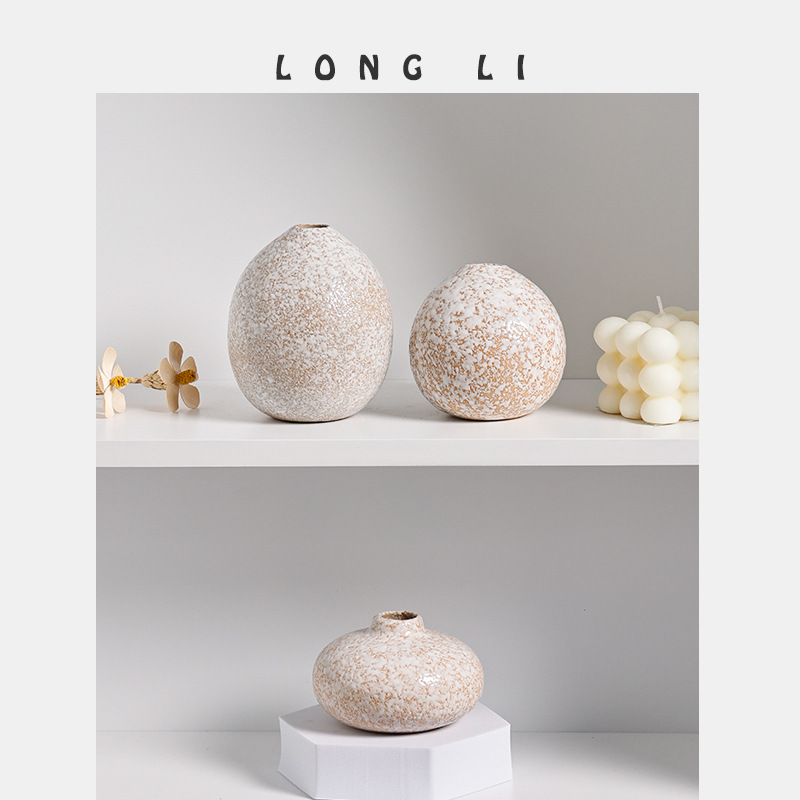 Speckled ceramic vases of different shapes styled on a shelf