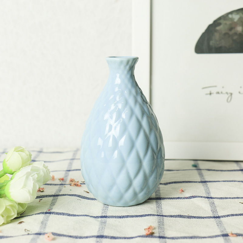 Pastel ceramic vase with one stem on a small surface