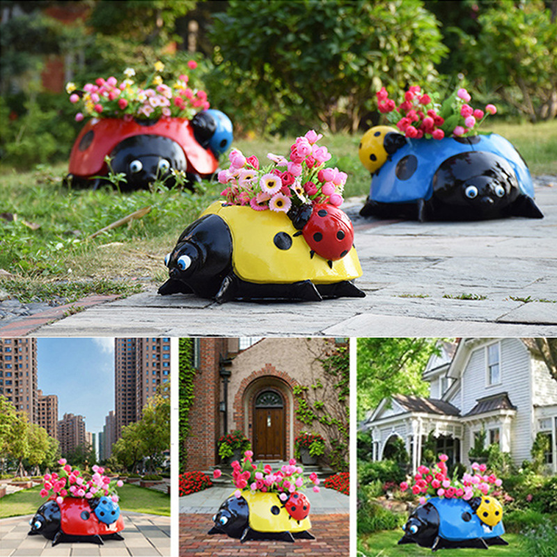 Three ladybug planters in red, yellow and blue on a patio