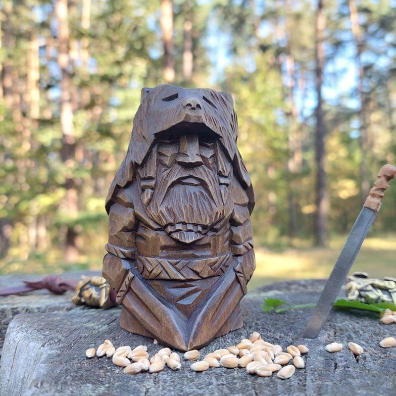 Carved Norse figure set styled on a rustic surface with soft light