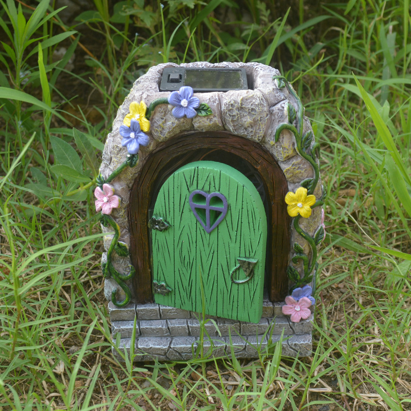 Front view of fairy door in grass showing solar panel on the roof