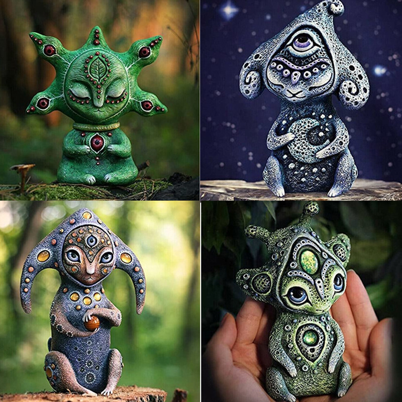 Resin fantasy creature placed in a garden corner with stones and soft daylight