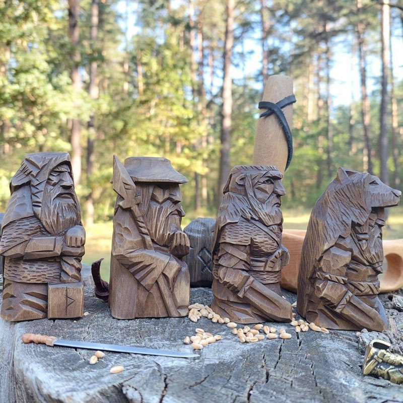 Side view of four carved Norse figures and the wolf-helm warrior