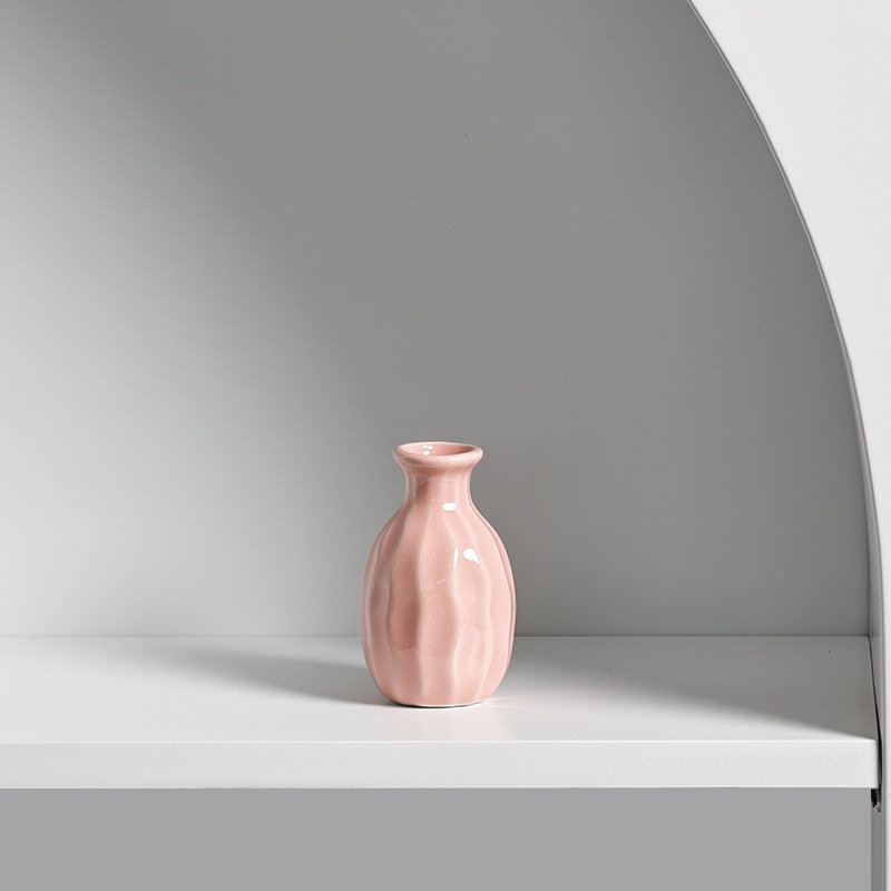 Close-up of a pink mini ceramic vase with glossy glaze and ridged body