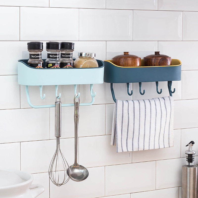 Mint and navy wall racks in a tiled kitchen holding spice jars and utensils
