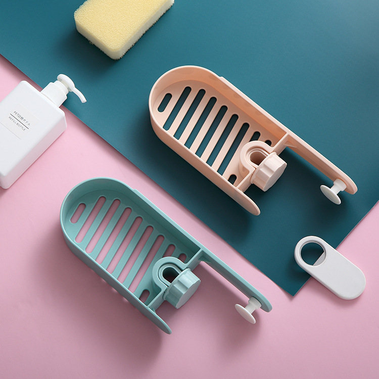 Peach and mint faucet racks beside a soap bottle and sponge