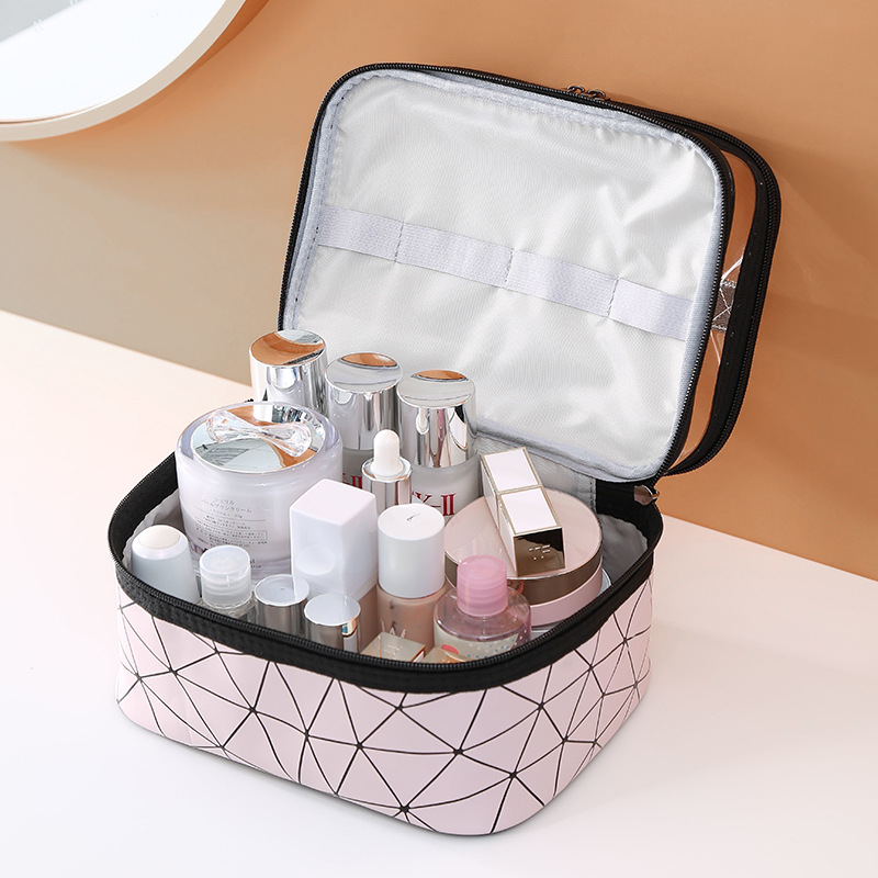 Open pink cosmetic bag with white lining, elastic strap, skincare jars and dropper bottle inside