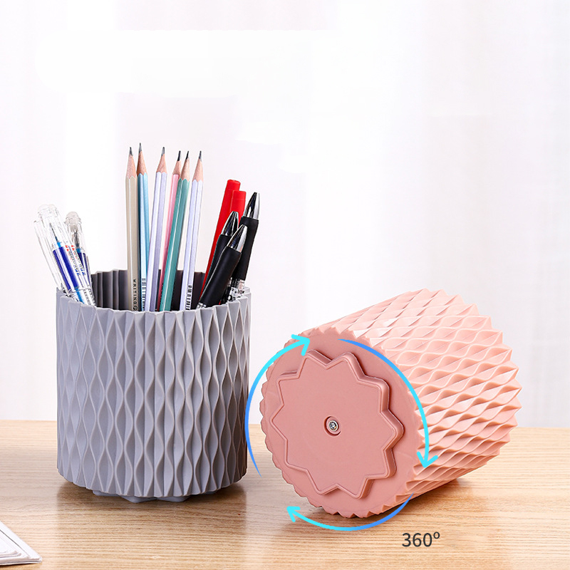 Grey pen holder being turned on its 360 degree base beside a pink holder