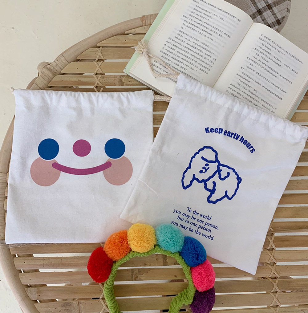 Cloud smile and poodle pouches beside a pom-pom headband on a rattan table