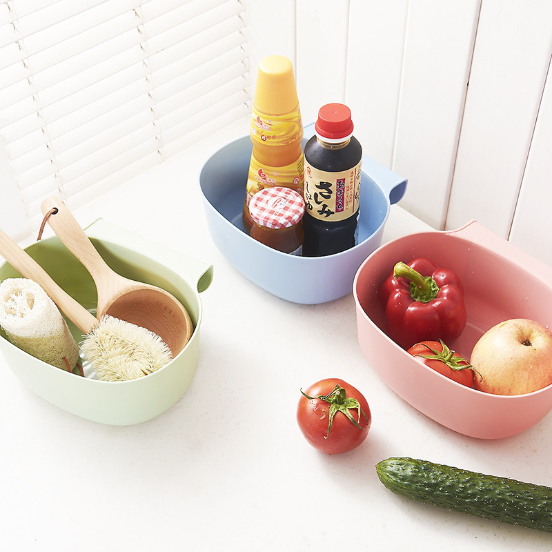 Green, blue and pink bins hung at the kitchen counter holding everyday prep scraps