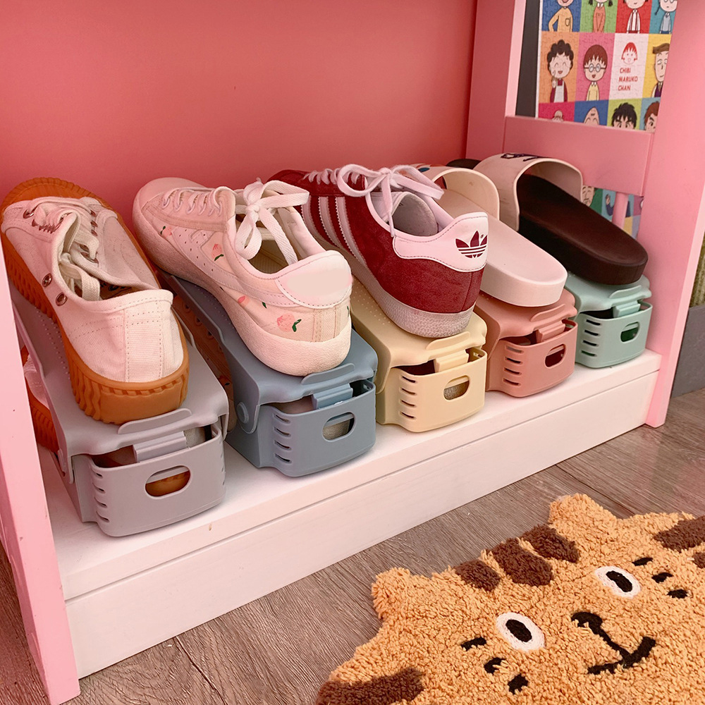 Pastel shoe racks stacked in a pink cabinet holding sneakers and slides
