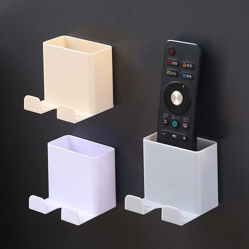Three wall caddies in cream, lavender and white, one holding a TV remote