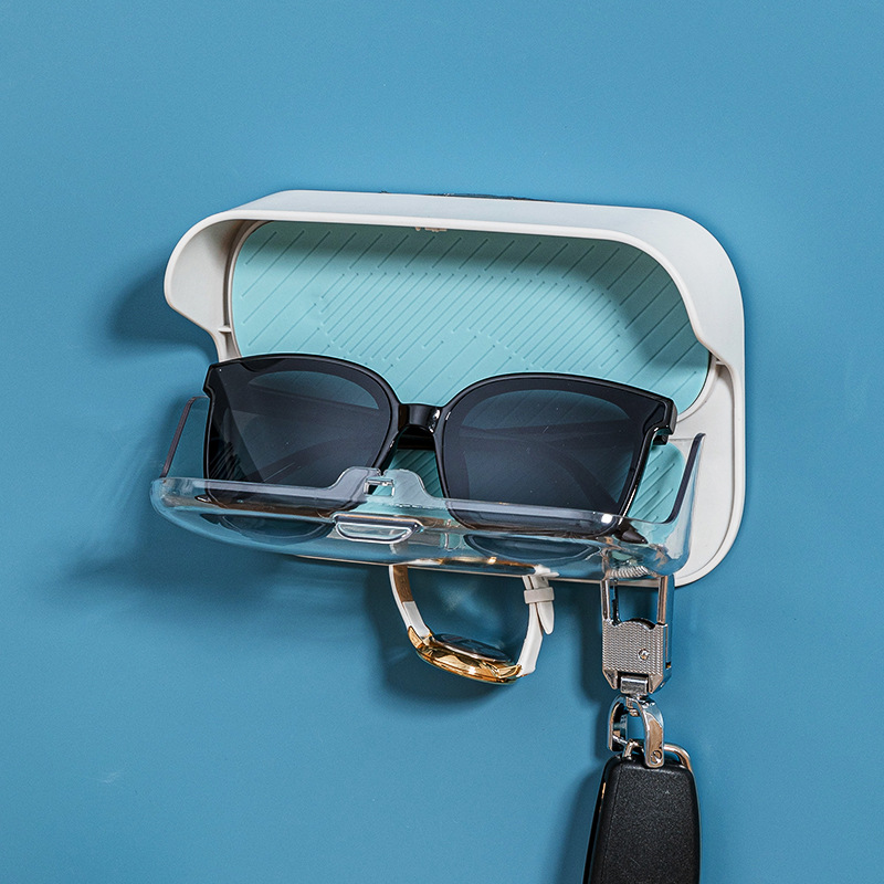 Three teal hooks holding a watch strap and a folded towel