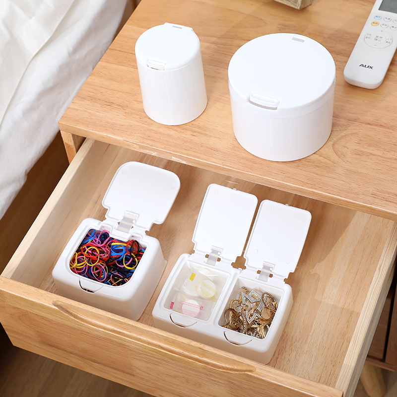 Storage boxes staged on a wooden bedside table and inside an open drawer