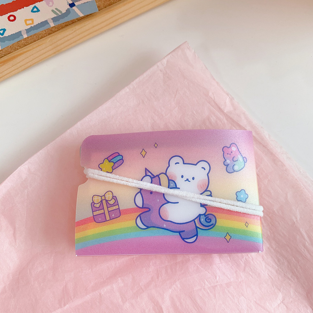 Pastel bear pouch with white elastic band closed on a desk