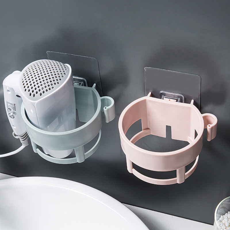 Mint and pink holders on a wall beside a bathroom sink