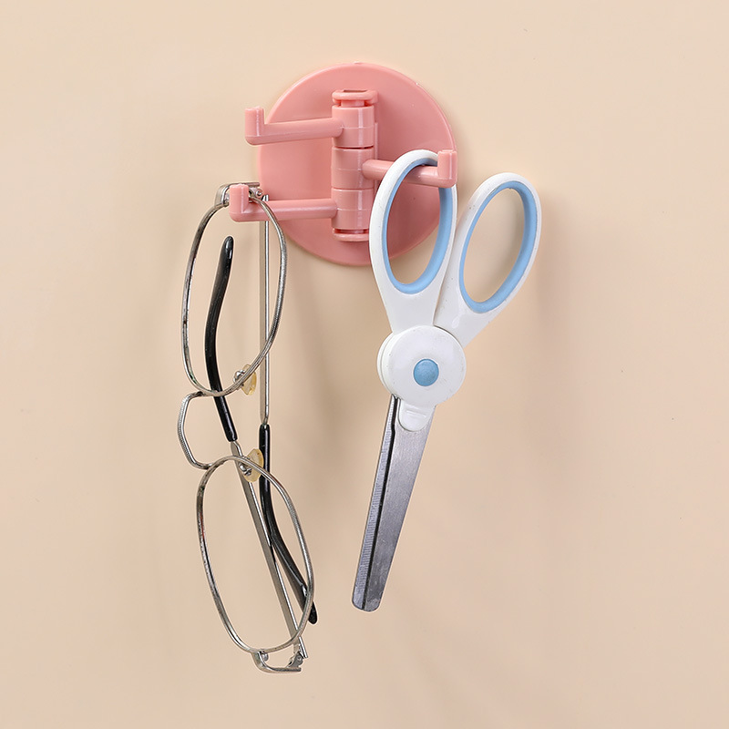 Pink rotating hook holding eyeglasses and a pair of scissors