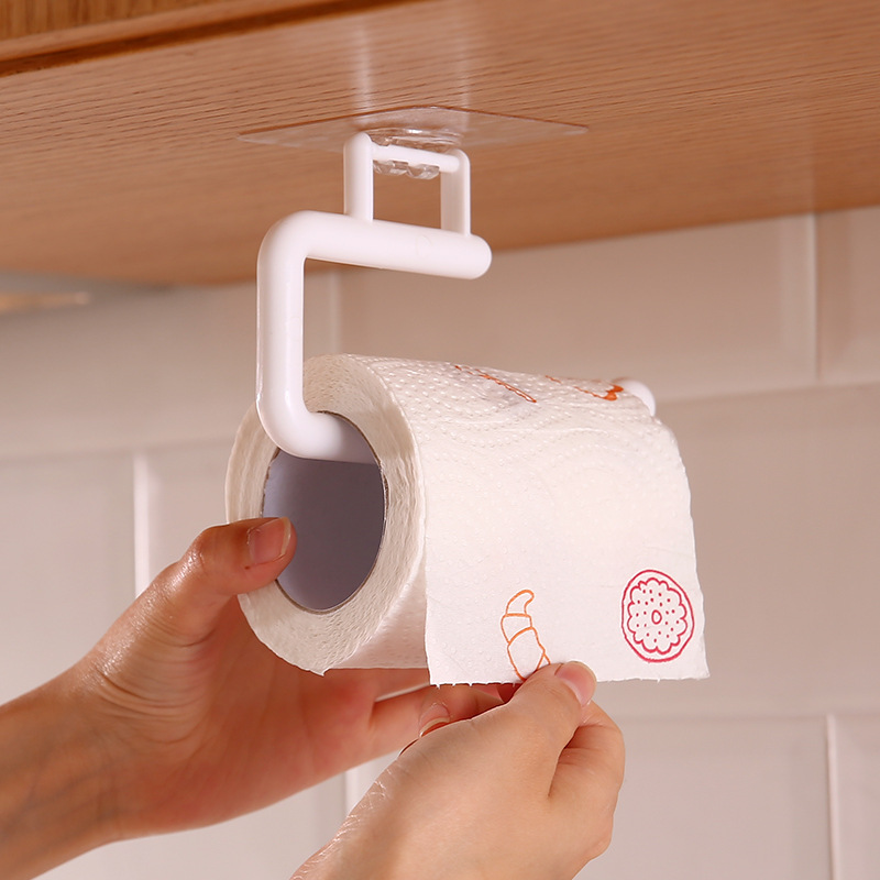 Hand tearing a paper towel from a white under-cabinet holder