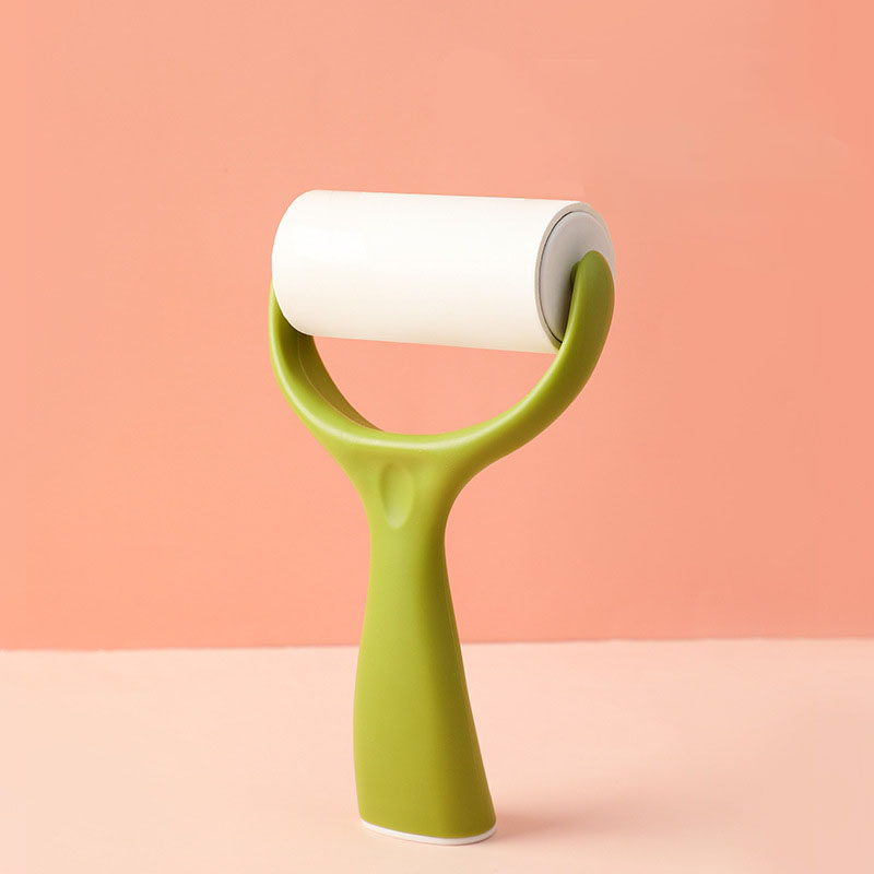 Sage green lint roller standing upright on its own handle