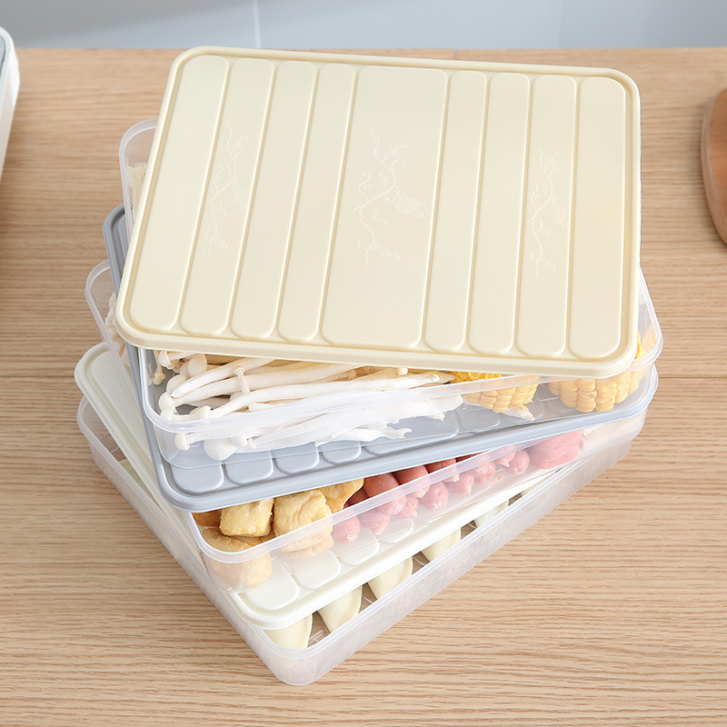 Stacked food boxes with cream and grey lids partly removed to show contents