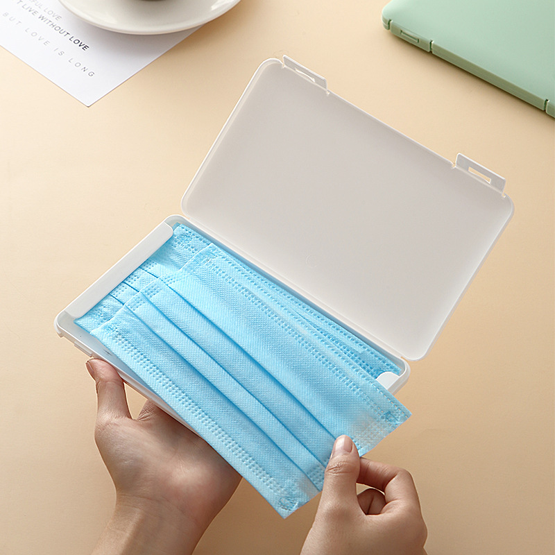 Hands opening a white mask case to take out a blue mask