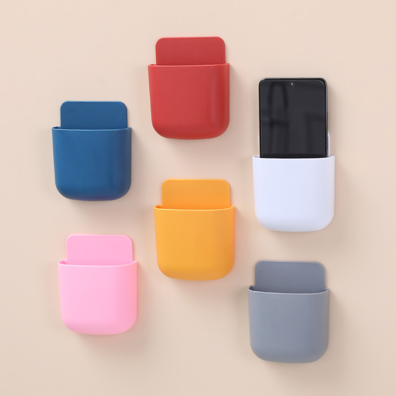 Staggered row of pastel wall pockets with phones standing upright inside