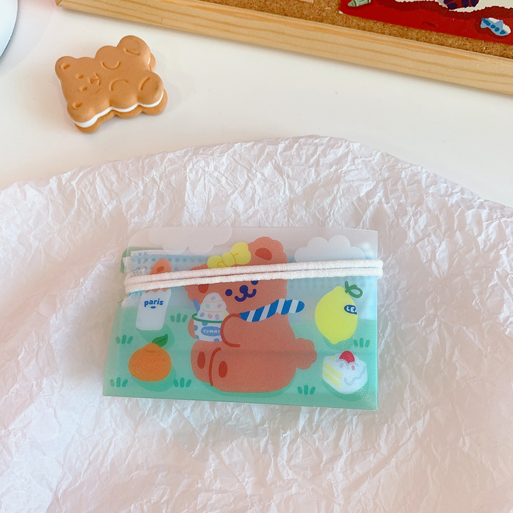 Mint green bear pouch with cake and fruit prints up close